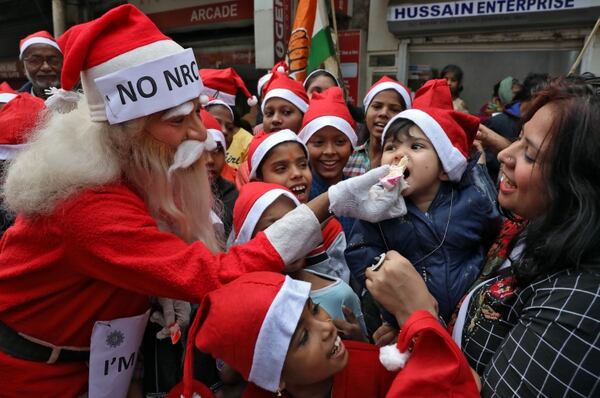Un hombre vestido de Santa Claus ofrece comida a un niño en Kolkata, India (REUTERS/Rupak De Chowdhuri)