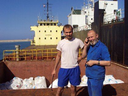 Boris Prokoshev (derecha), capitán del buque de carga Rhosus, y el contramaestre Boris Musinchak posan junto a una bodega de carga cargada con nitrato de amonio en el puerto de Beirut (Líbano), en una fotografía del verano de 2014 (REUTERS/Archivos personales de Boris Musinchak)
