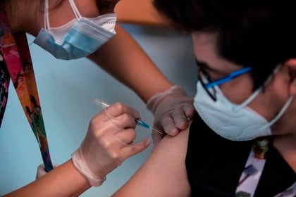 Un trabajador sanitario recibe la vacuna contra la COVID-19, en el Hospital de Urgencia Asistencia Pública en Santiago (Chile)
