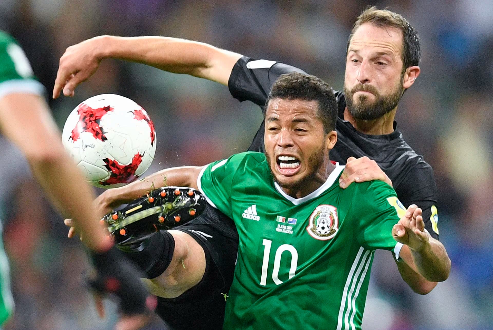 El mexicano Giovani Dos Santos es desafiado por Andrew Durante, de Nueva Zelanda, durante la Copa Confederaciones
