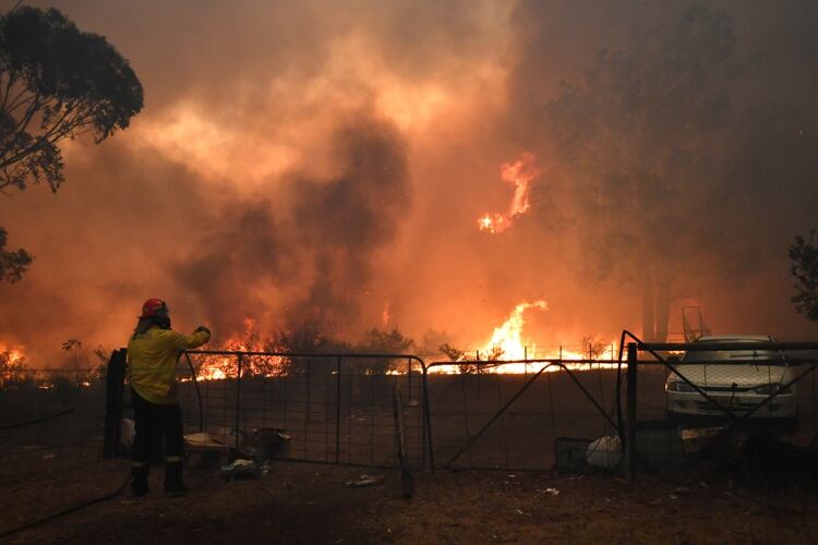 Operativos de los bomberos para proteger las viviendas al borde del incendio, al suroeste de Sidney (Reuters)