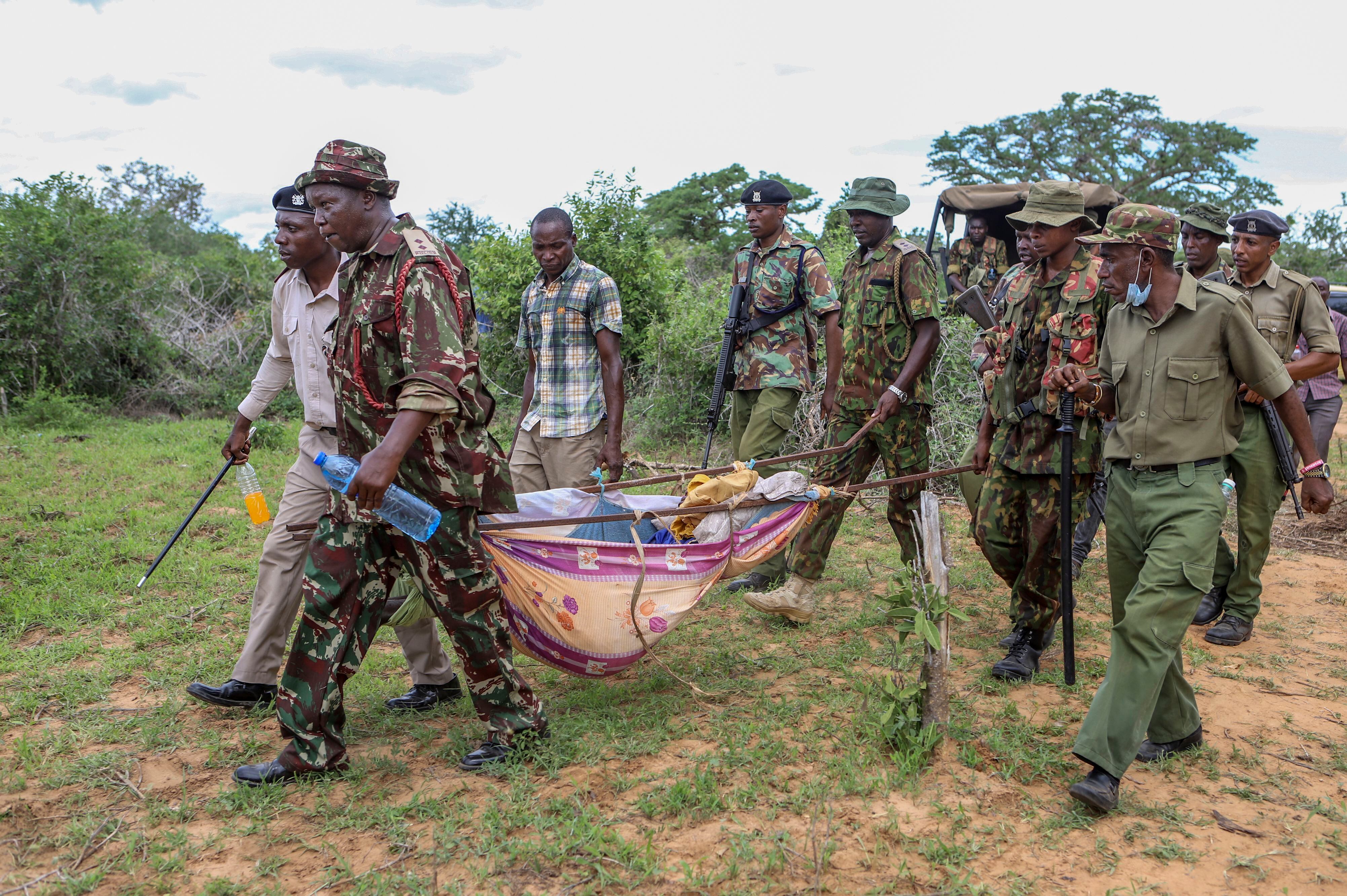 Agentes de la policía y residentes cargan cuerpos exhumados de víctimas de una secta religiosa en la localidad de Shakahola, en el sur de Kenia (AP Foto)