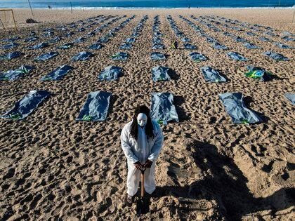 Foto tomada con un dron que muestra elementos que simulan cerca de 400 bolsas mortuorias durante el acto de la ONG Río de Paz en memoria de los más de 400.000 brasileños muertos por el Covid-19, este viernes en las arenas de la playa de Copacabana, en la zona sur de Río de Janeiro, Brasil. EFE/Antonio Lacerda
