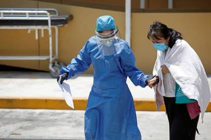 Una trabajadora de la salud acompaña a una paciente contagiada de coronavirus a una estación de cribaje, en el Hospital General de Ciudad de México el 23 de abril de 2020 (Reuters/ Gustavo Graf)