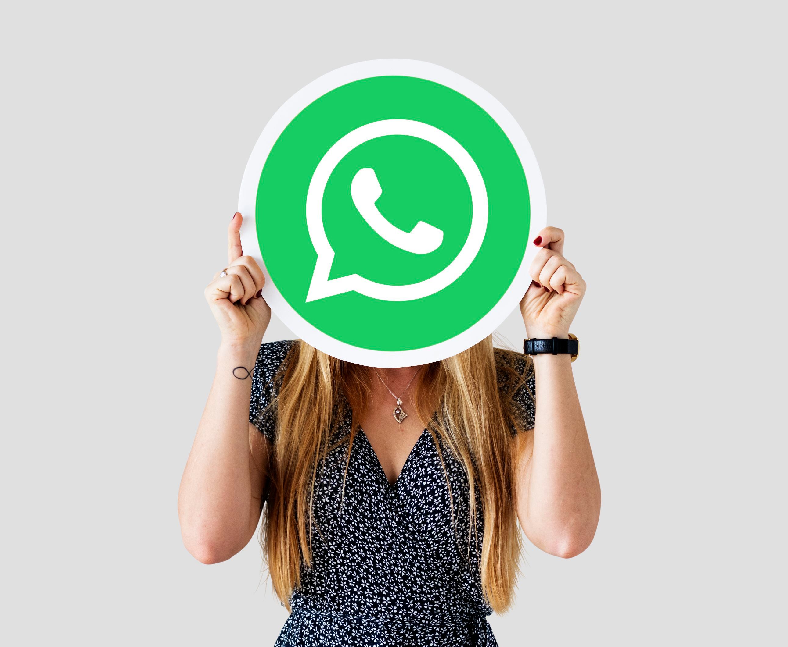 Una mujer sujeta el logo de whatsApp. (FREEPIK)