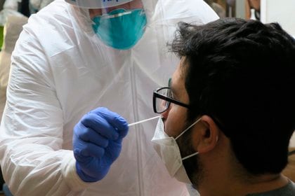 Un técnico de laboratorio inserta un hisopo en la nariz de un joven. EFE/ Jorge Muñiz/Archivo

