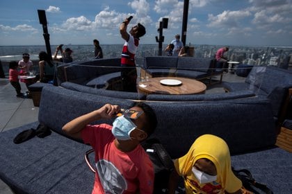 Personas en Bangkok, Thailand, observan el eclipse de 2019 -. REUTERS/Athit Perawongmetha