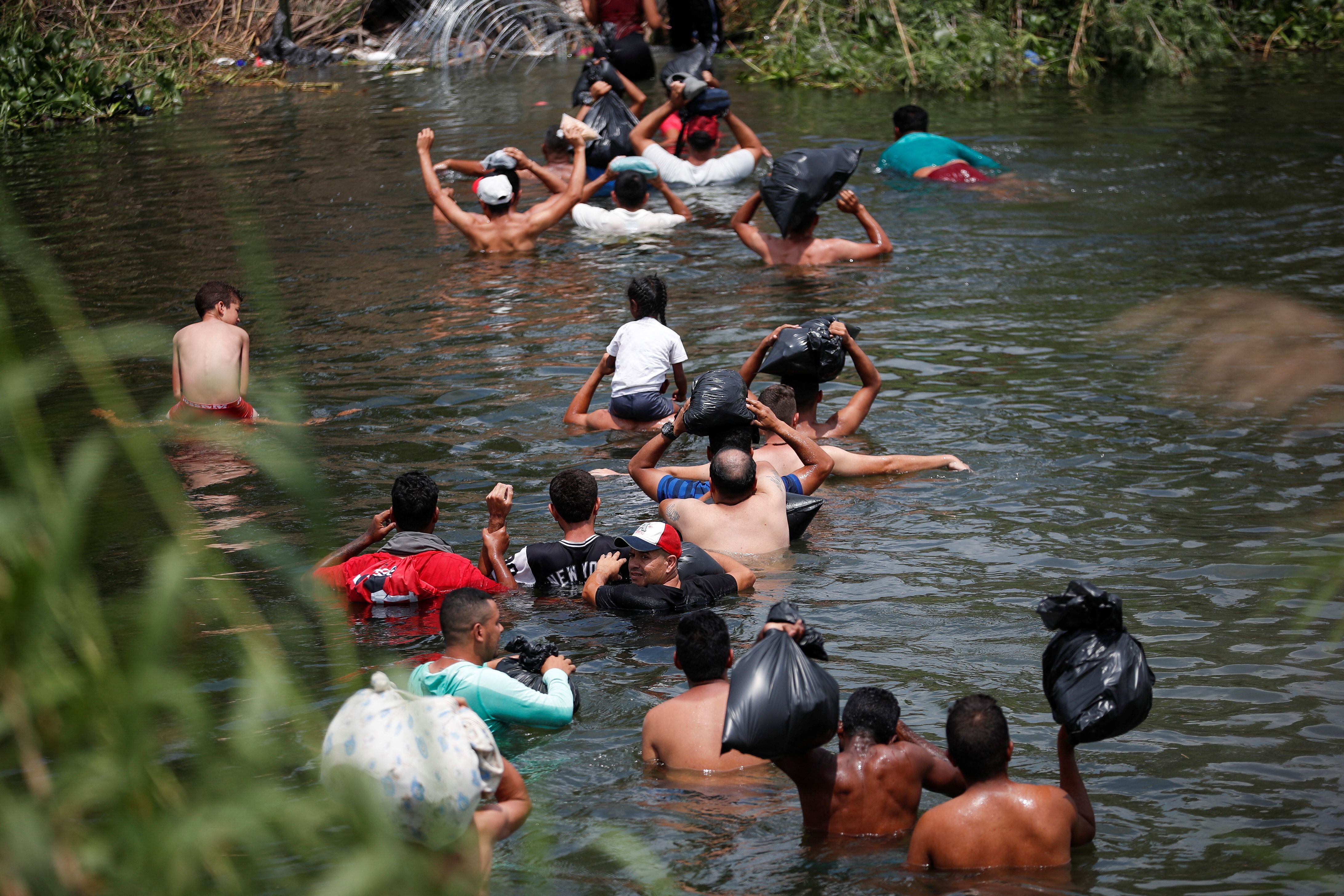 Migrants cross the Rio Bravo river to turn themselves in to U.S. Border Patrol agents before the lifting of Title 42, in Matamoros, Mexico May 11, 2023. REUTERS/Daniel Becerril