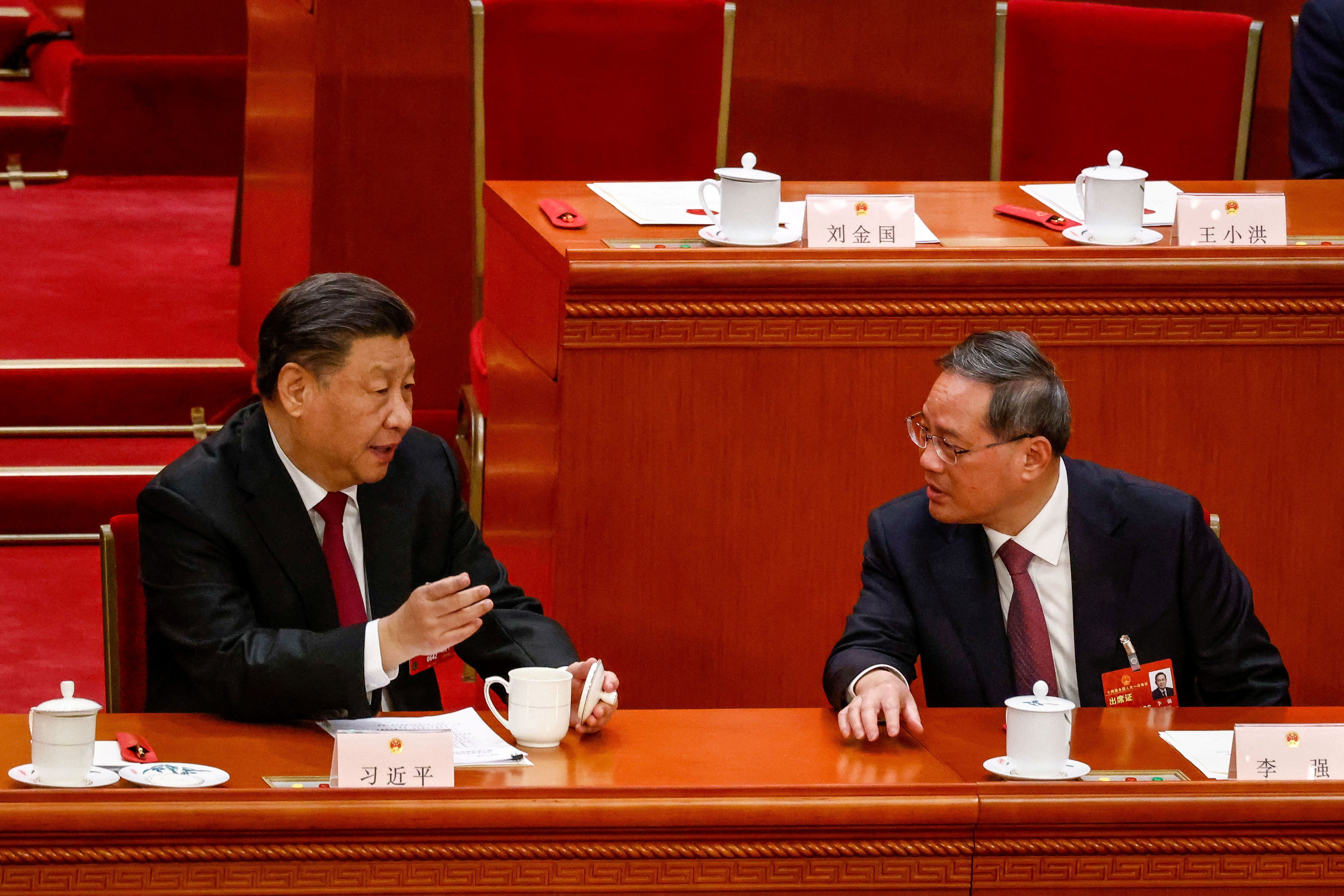 Xi Jinping habla al primer ministro Li Qiang durante la Tercera Sesión Plenaria de la Asamblea Popular Nacional (APN) en el Gran Salón del Pueblo (MARK R. CRISTINO/REUTERS)