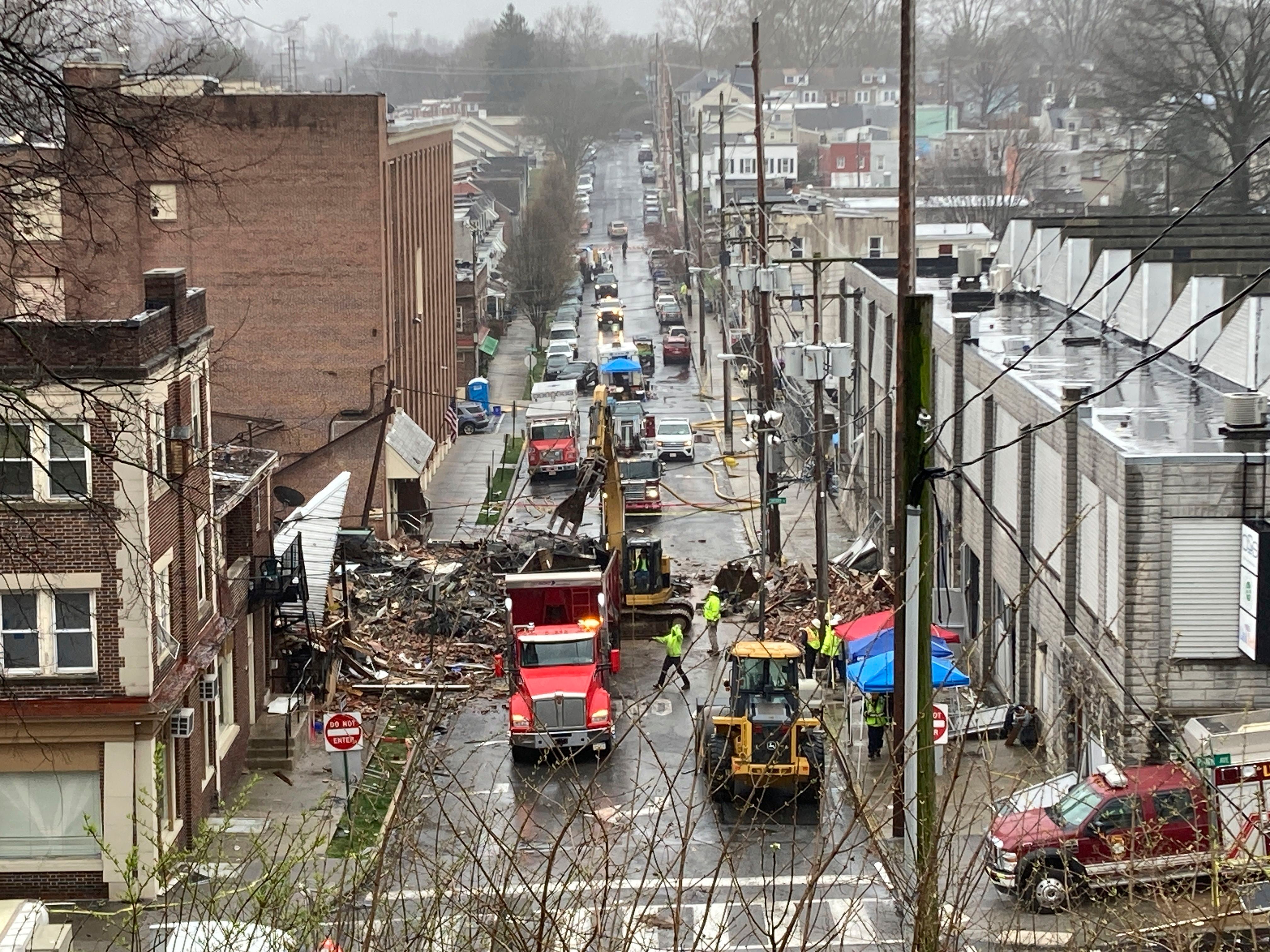 Socorristas con maquinaria pesada laboran en el sitio donde ocurrió una explosión en una fábrica de chocolate, el sábado 25 de marzo de 2023, en West Reading, Pensilvania. (AP Foto/Michael Rubinkam)