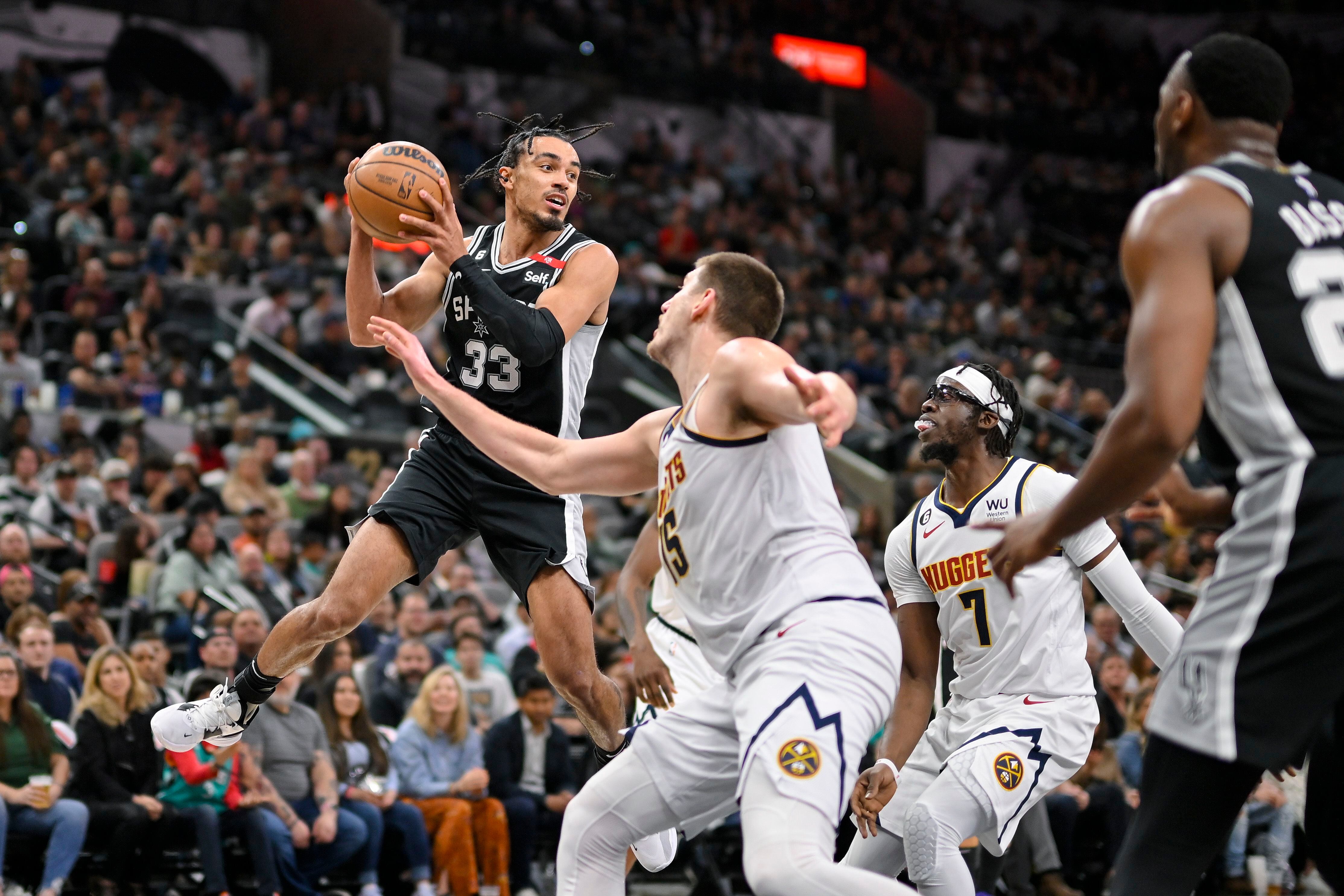 Tre Jones, de los Spurs de San Antonio, busca enviar un pase frente a Nikola Jokic y Reggie Jackson (7), de los Nuggets de Denver, el viernes 10 de marzo de 2023 (AP Foto/Darren Abate)