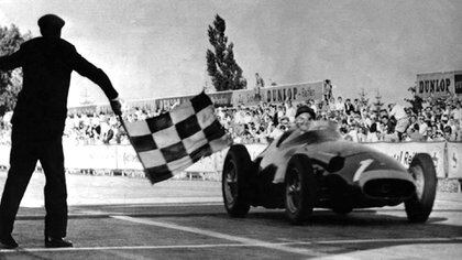 Recibiendo la bandera de cuadros en Nürburgring 1957, el día que logró su quinto título (Museo Fangio).