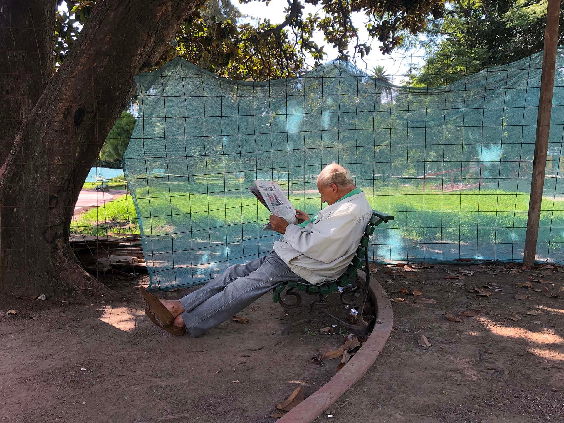 Un hombre leyendo un diario en un domingo de muchísimo calor en febrero de 2019 bajo la sombra de un árbol del Parque Rivadavia. Al artista reflexionó: "Este hombre estaba tranquilo, bajo un árbol, con una campera, leyendo su diario sin que nadie lo distrajera. Ya no se suele ver mucha gente leyendo diarios en la calle" 