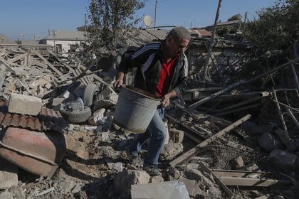 Un hombre levanta escombros de un edificio bombardeado en Nagorno Karabij.  Reuters / Fotógrafo autónomo