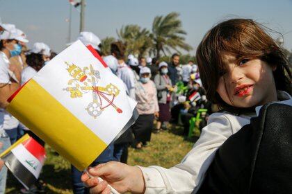 Un niño con una bandera del Vaticano esperando la llegada del Papa (REUTERS/Thaier al-Sudani)