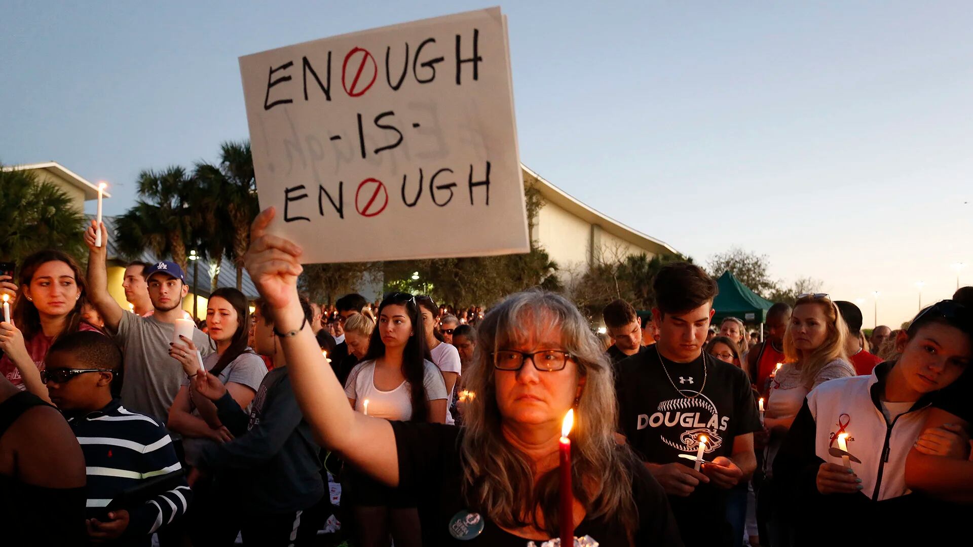 Miles de personas sostienen velas durante una vigilia por las víctimas de la balacera de la Marjory Stoneman Douglas High School en Parkland, Florida (AFP)
