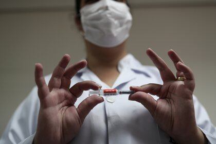 Una enfermera sotiene la vacuna potencial de coronavirus SinoVac de China para ensayos antes de administrarla a un voluntario en el Instituto Emilio Ribas en San Pablo, Brasil (Reuters)