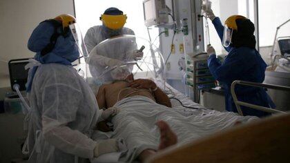 Un médico y dos enfermeras tratan a un paciente aquejado de coronavirus en la UCI del hospital El Tunal en Bogotá, Colombia. 12 junio 2020. REUTERS/Luis González