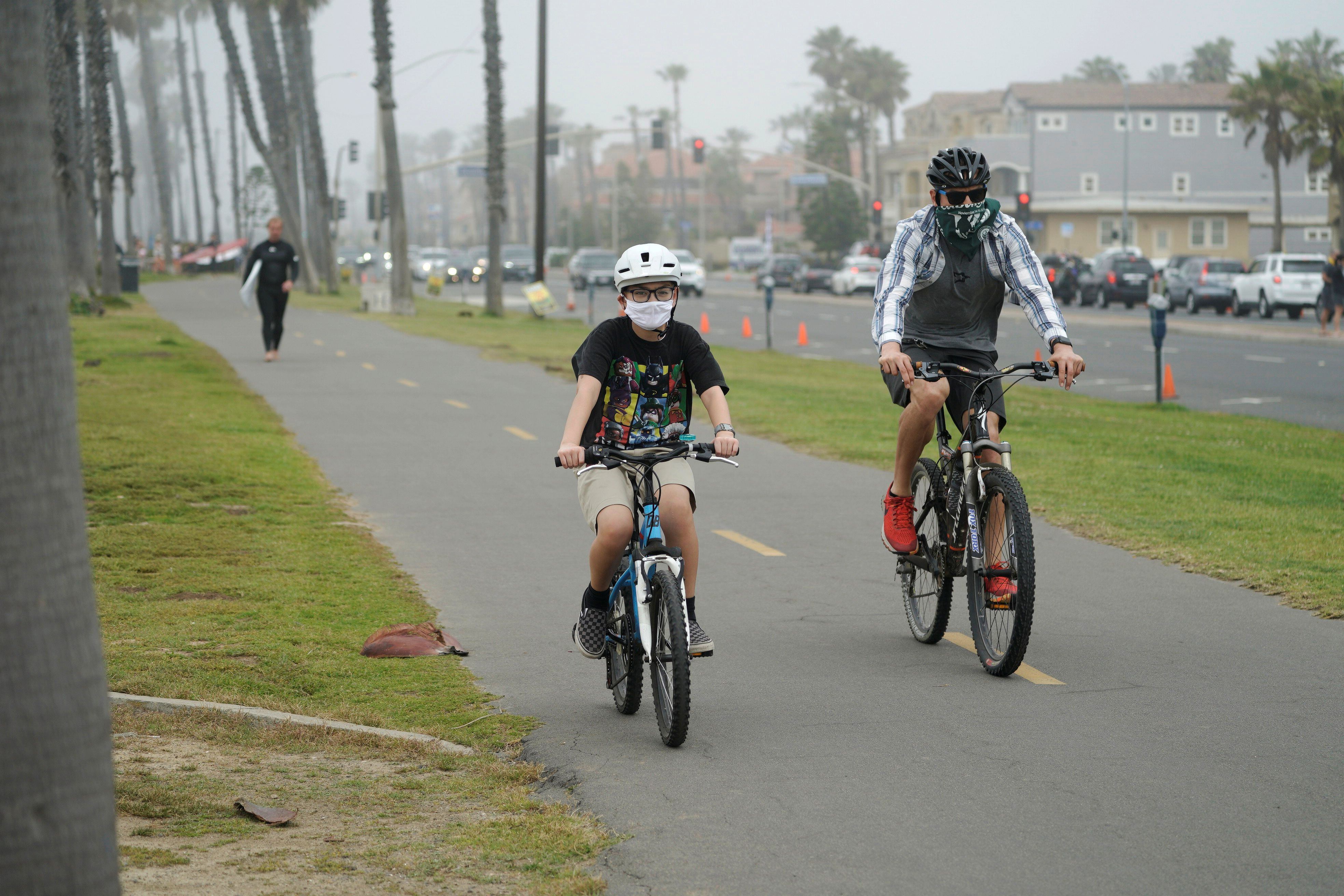Los ciclistas recorren Huntington City Beach durante el brote de la enfermedad coronavirus (COVID-19) en Huntington Beach, California, EE.UU.