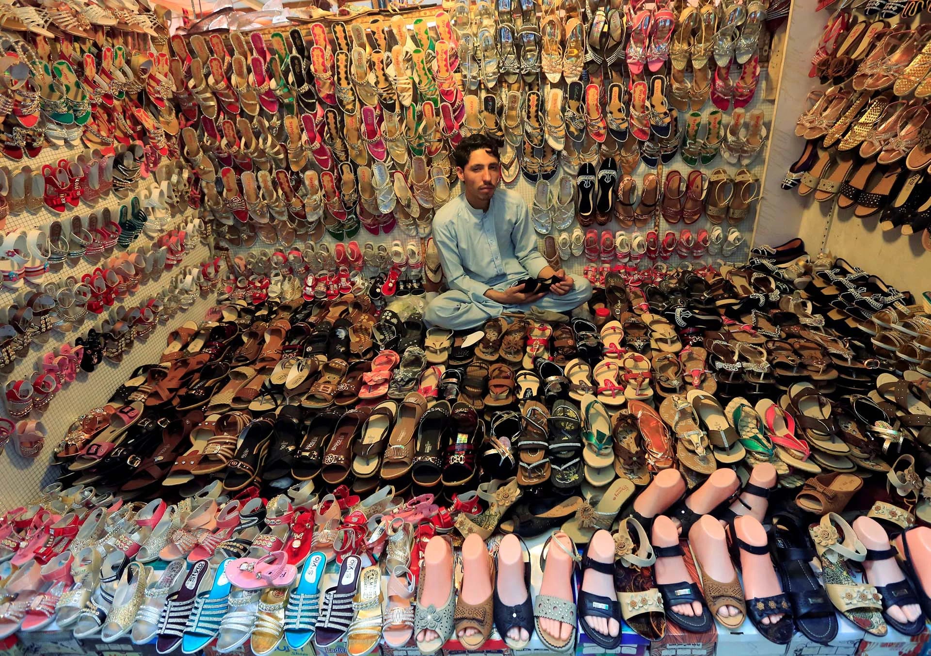 Un hombre afgano vende sandalias en Jalalabad, Afganistan