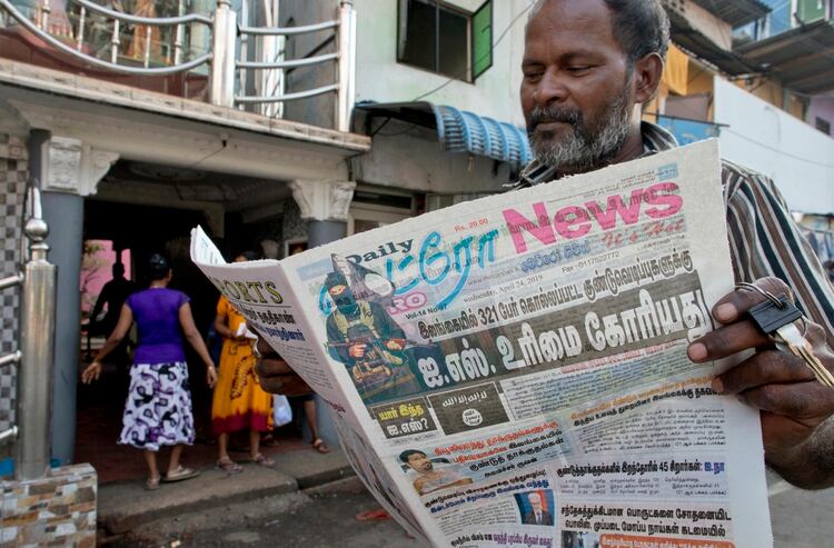 Un hombre lee un periodo con un titular que recoge la reclamación de Estado Islámico sobre la autoría de los ataques del Domingo de Pascua en Colombo, Sri Lanka, el 24 de abril de 2019. (AP Foto/Gemunu Amarasinghe)