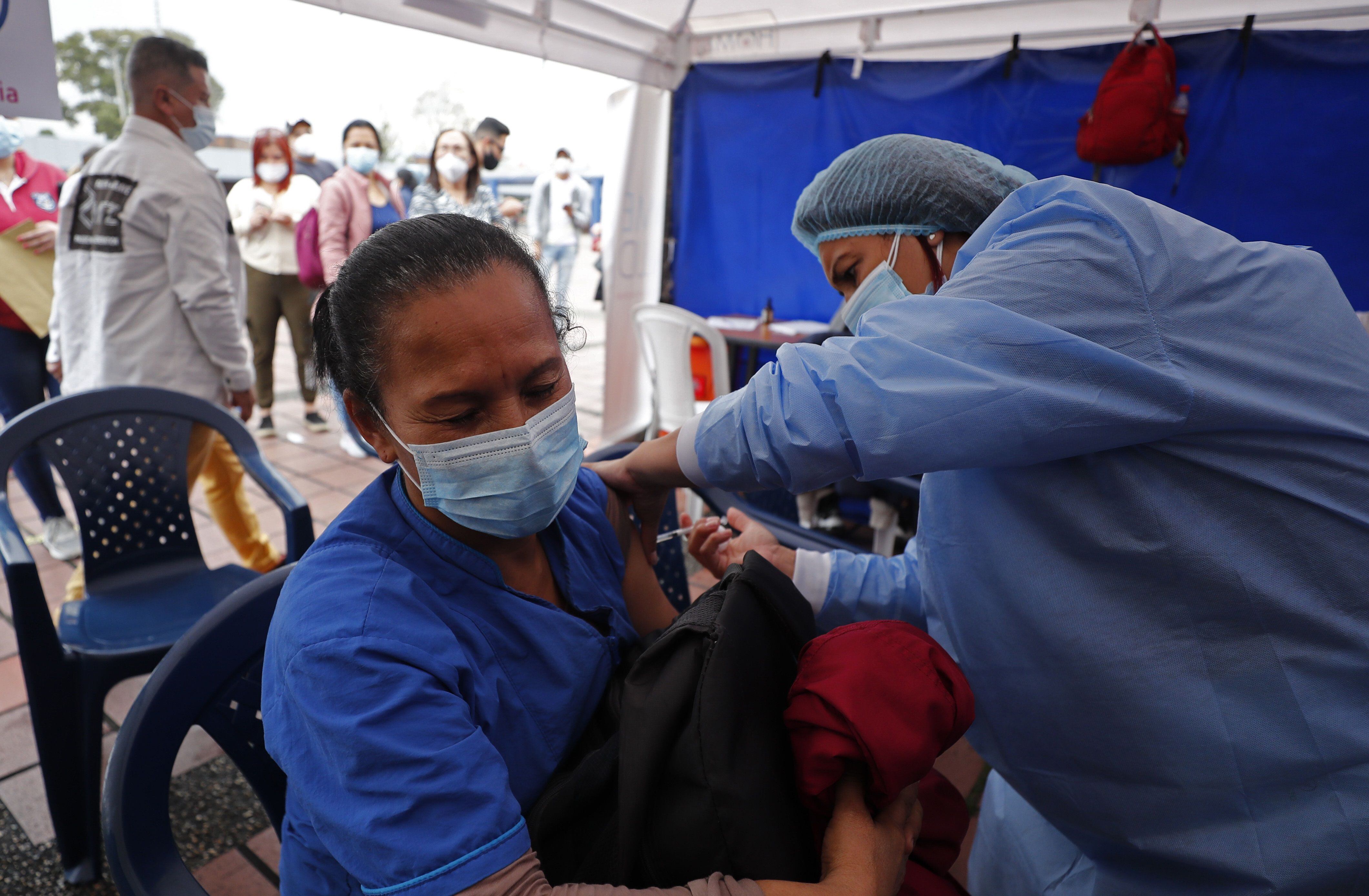 Fotografía de archivo de una mujer mientras es vacunada contra covid-19, en Bogotá (Colombia). EFE/ Mauricio Dueñas Castañeda