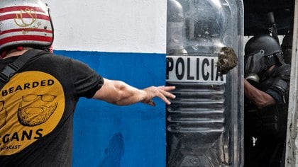 Manifestante arroja piedra a la policía (AFP)