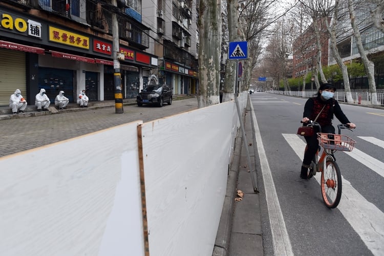 Una mujer en bicicleta se desplza por la ciudad desierta (REUTERS/Stringer CHINA OUT)