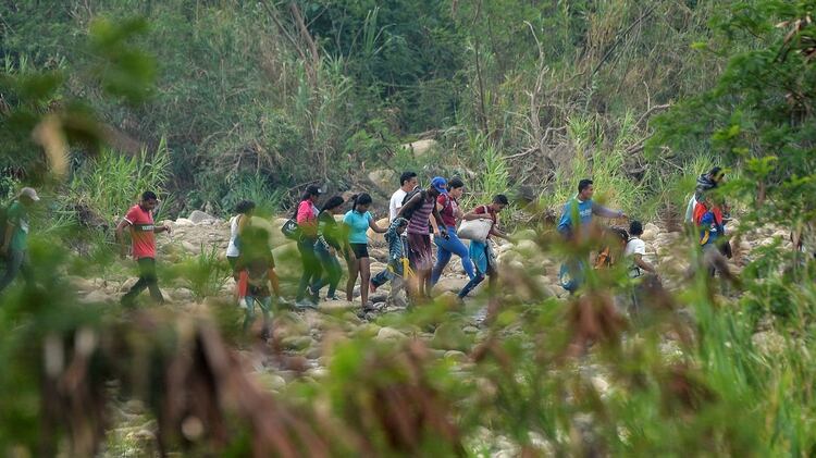 La gente cruza a través de “Trochas” – senderos ilegales– a través del río Táchira desde San Antonio en Venezuela a Cúcuta en Colombia el 27 de febrero de 2019.  (Foto de Luis ROBAYO / AFP)