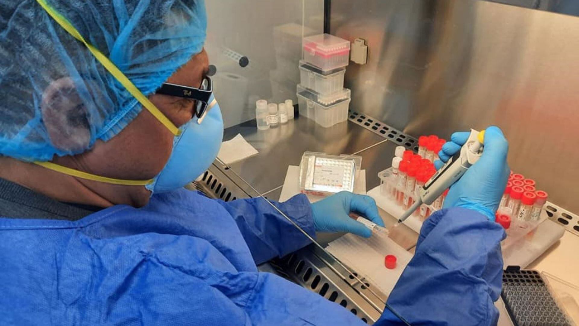 Médico con mascarilla evalúa una prueba de Covid-19 en un laboratorio.