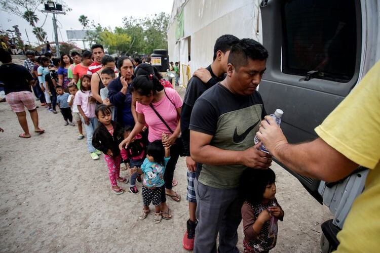 Inmigrantes hacen fila para obtener agua en un campamento de más de 2.000 personas que buscan asilo en Estados Unidos, mientras las autoridades locales se preparan para responder a la enfermedad del coronavirus (COVID-19) en Matamoros, México (REUTERS/Daniel Becerril/Archivo)