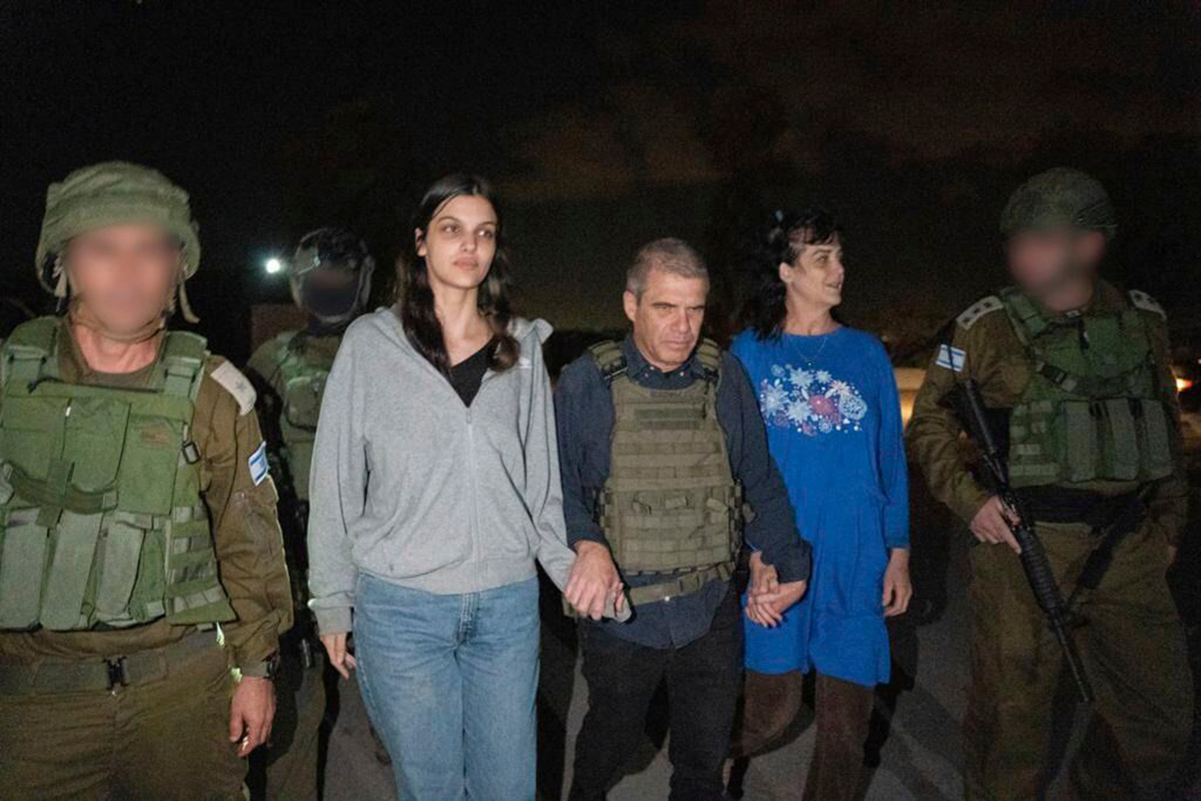 Judith Raanan (derecha) y su hija de 17 años de edad, Natalie, son escoltadas por soldados israelíes y Gal Hirsch, el coordinador especial del primer ministro Benjamin Netanyahu para regresar a rehenes a Israel (Gobierno de Israel vía AP Foto)