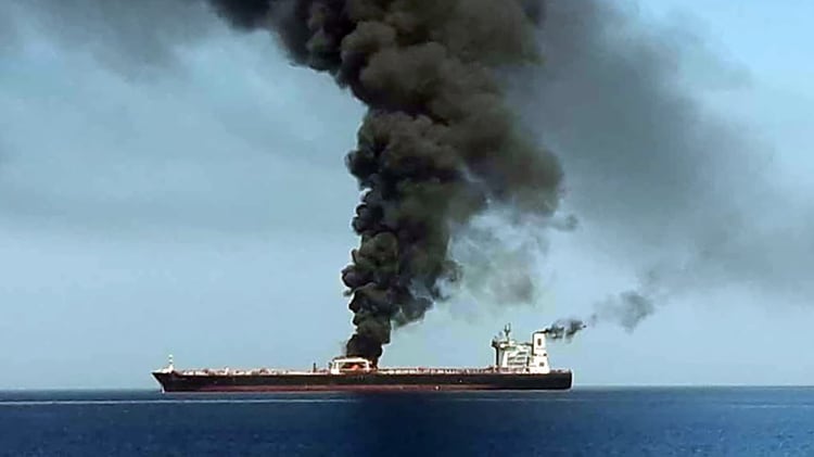 Una foto obtenida por AFP de la televisión estatal iraní IRIB el 13 de junio de 2019 muestra humo que se eleva desde un buque petrolero que supuestamente fue atacado frente a la costa de Omán (Foto de HO / IRIB TV / AFP)