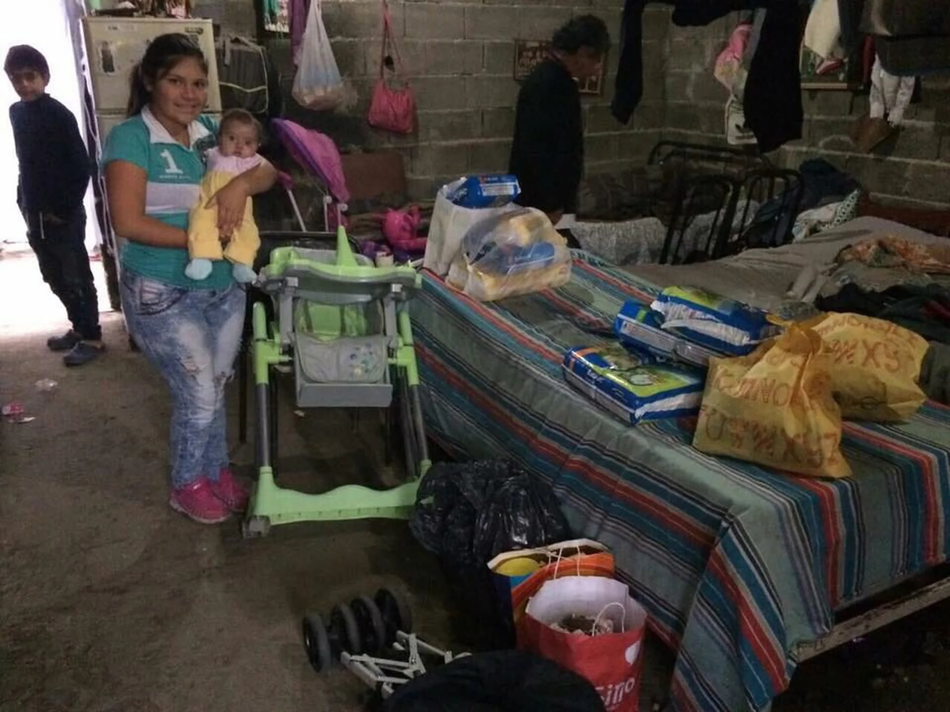 Milagros junto a su mamá con donaciones entregadas por Madres Leonas