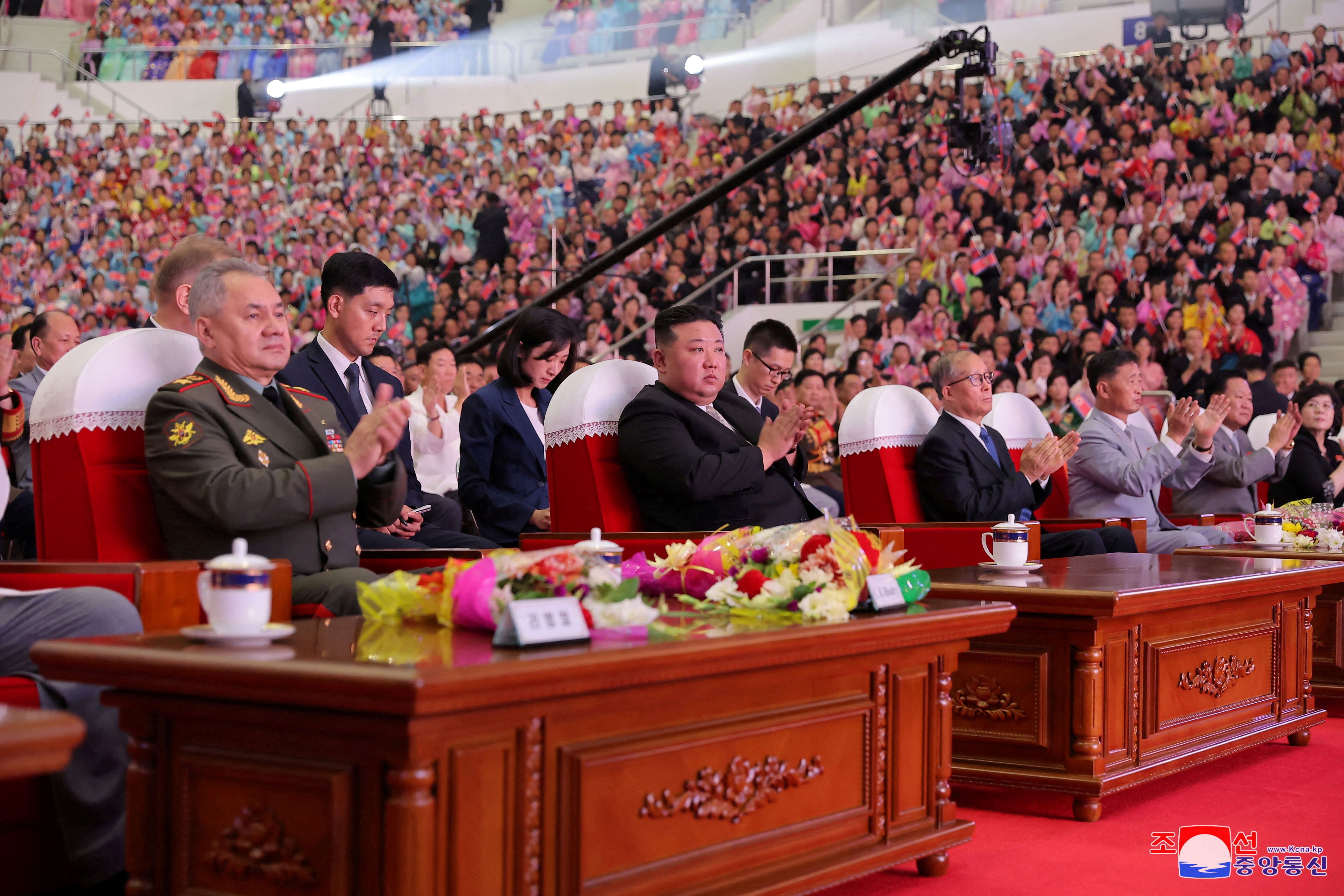 Kim Jong-un aplaude el show entre sus invitados, el ministro ruso Shoigu y el delegado chino Li Hongzhong (KCNA/Reuters)
