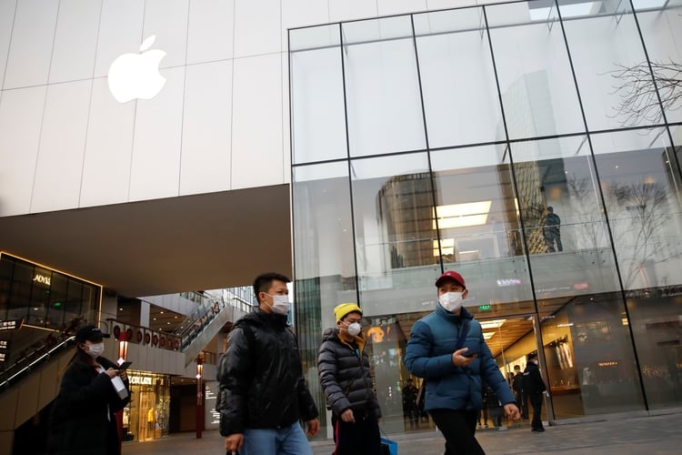 Personas con máscaras faciales, pasan por delante de una tienda de Apple en un centro comercial, mientras el país es golpeado por un brote del nuevo coronavirus, en Pekín, China, el 18 de febrero de 2020 (REUTERS/Carlos García Rawlins)