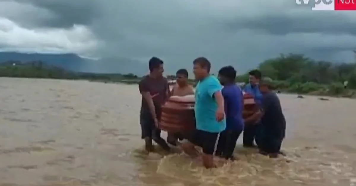 Cyclone Yaku: Victims of the rains in Tumbes cross a ravine with the coffin of a loved one