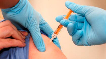 Un trabajador sanitario recibe una dosis de la vacuna contra la gripe A en el hospital University College London de Londres (EFE)