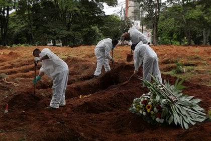 Foto de archivo de trabajadores de un cementerio en Sao Paulo depositando el ataúd de un fallecido como consecuencia del coronavirus. Dic 25, 2020. REUTERS/Amanda Perobelli