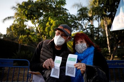 Adultos mayores vacunados muestran sus "pases verdes", que los habilitan a realizar distintas actividades en el país. Foto: REUTERS/Amir Cohen