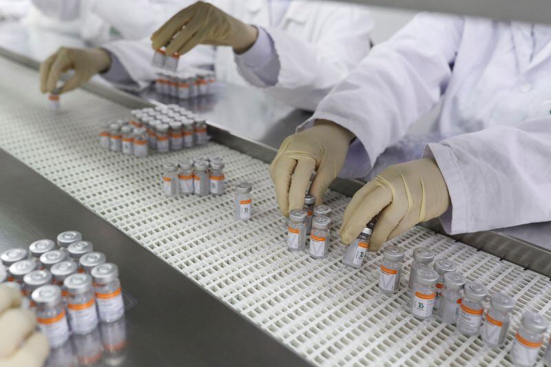 Trabajadores colocan vacunas contra el COVID-19 de Sinovac en bandejas en el centro de producción biomédico Butantan, Sao Paulo, Brasil (Reuters)