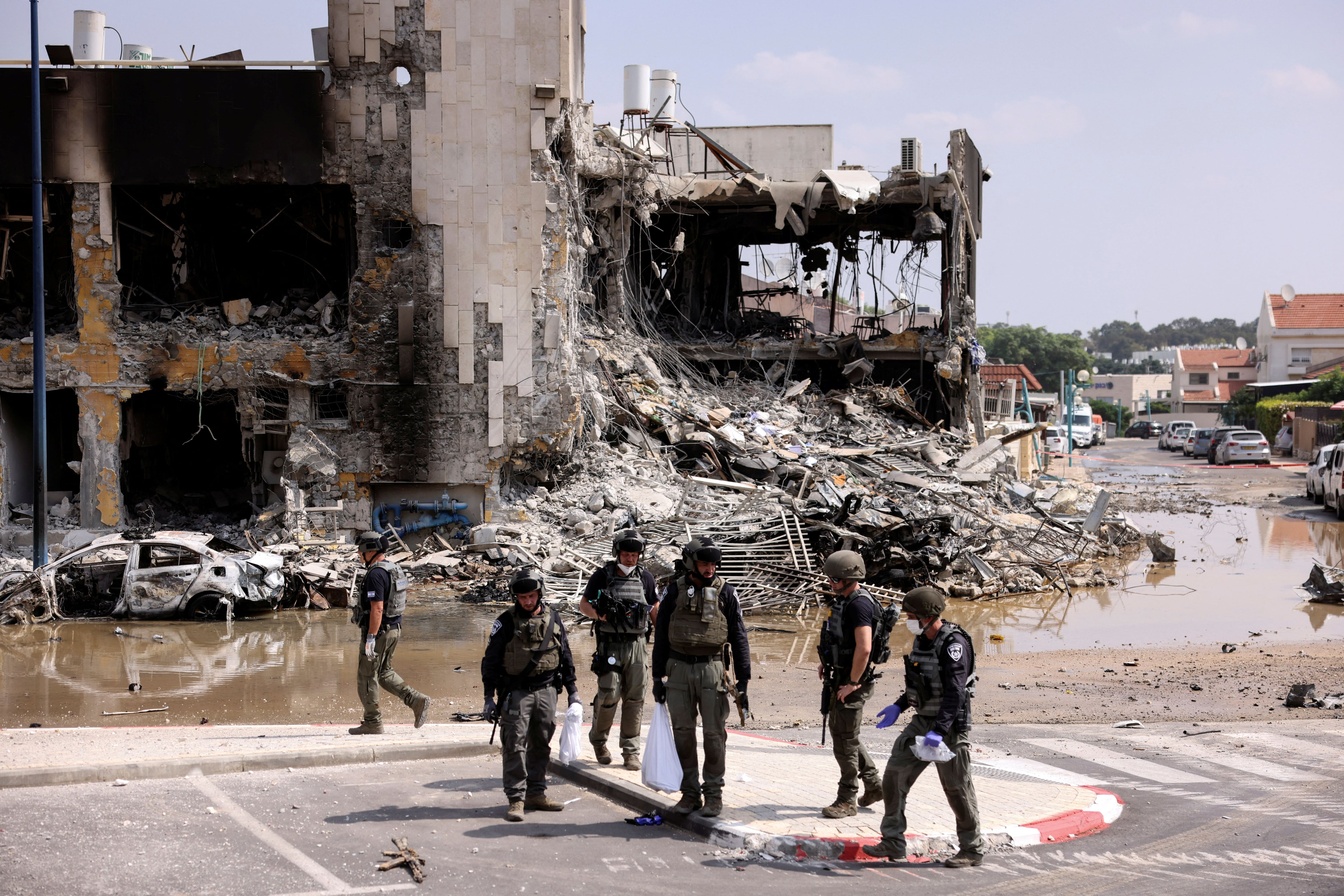 La seguridad israelí se reúne cerca de un rifle en el lugar de una batalla tras una infiltración masiva de hombres armados de Hamás desde la Franja de Gaza, en Sderot, sur de Israel, 8 de octubre de 2023. REUTERS/Ronen Zvulun
