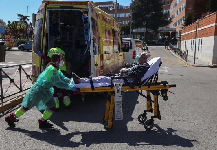 Una trabajadora sanitaria empuja una camilla con un traje protector en Madrid (Reuters)