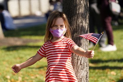 Una niña flamea una bandera estadounidense tras el anuncio de la victoria de Joe Biden en la presidencia de EEUU, en Wilmington, Delaware.  REUTERS/Kevin Lamarque
