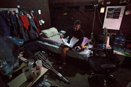 Luis, de 47 años, sentado en su cama (Cristian Hernandez / AFP)