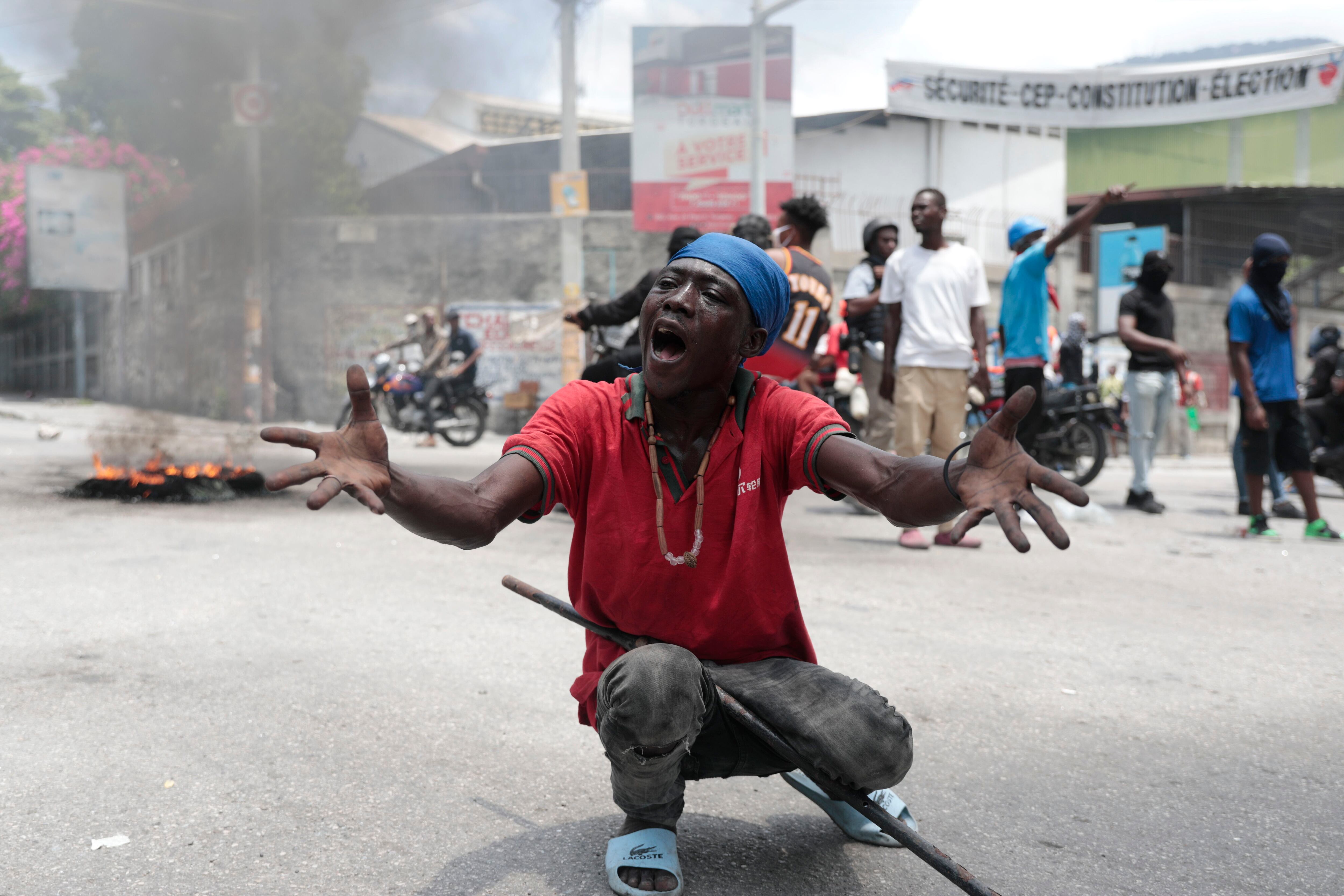 Un hombre pide a los reporteros que expliquen cómo el gobierno los abandonó y permitió que las bandas tomen el control, durante una protesta para reclamar protección frente a las pandillas violentas, en Puerto Príncipe, Haití, el 14 de agosto de 2023 (AP Foto/Odelyn Joseph)