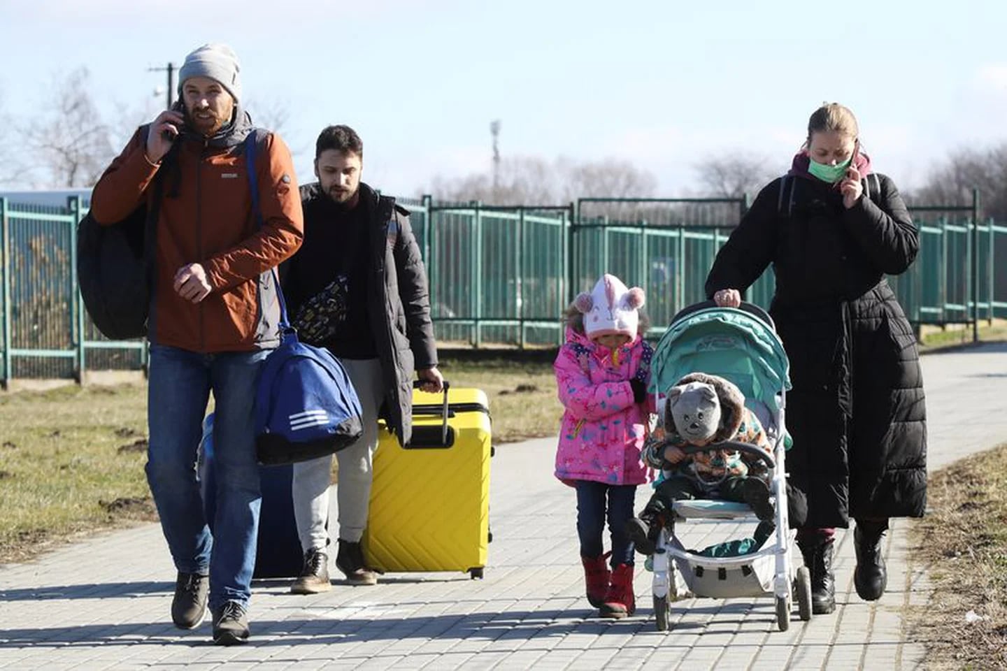 Adultos y niños caminan en un paso fronterizo entre Polonia y Ucrania, después de que el presidente ruso Vladimir Putin autorizara una operación militar en el este de Ucrania, en Medyka, Polonia. 24 de febrero de 2022. REUTERS/Kacper Pempel