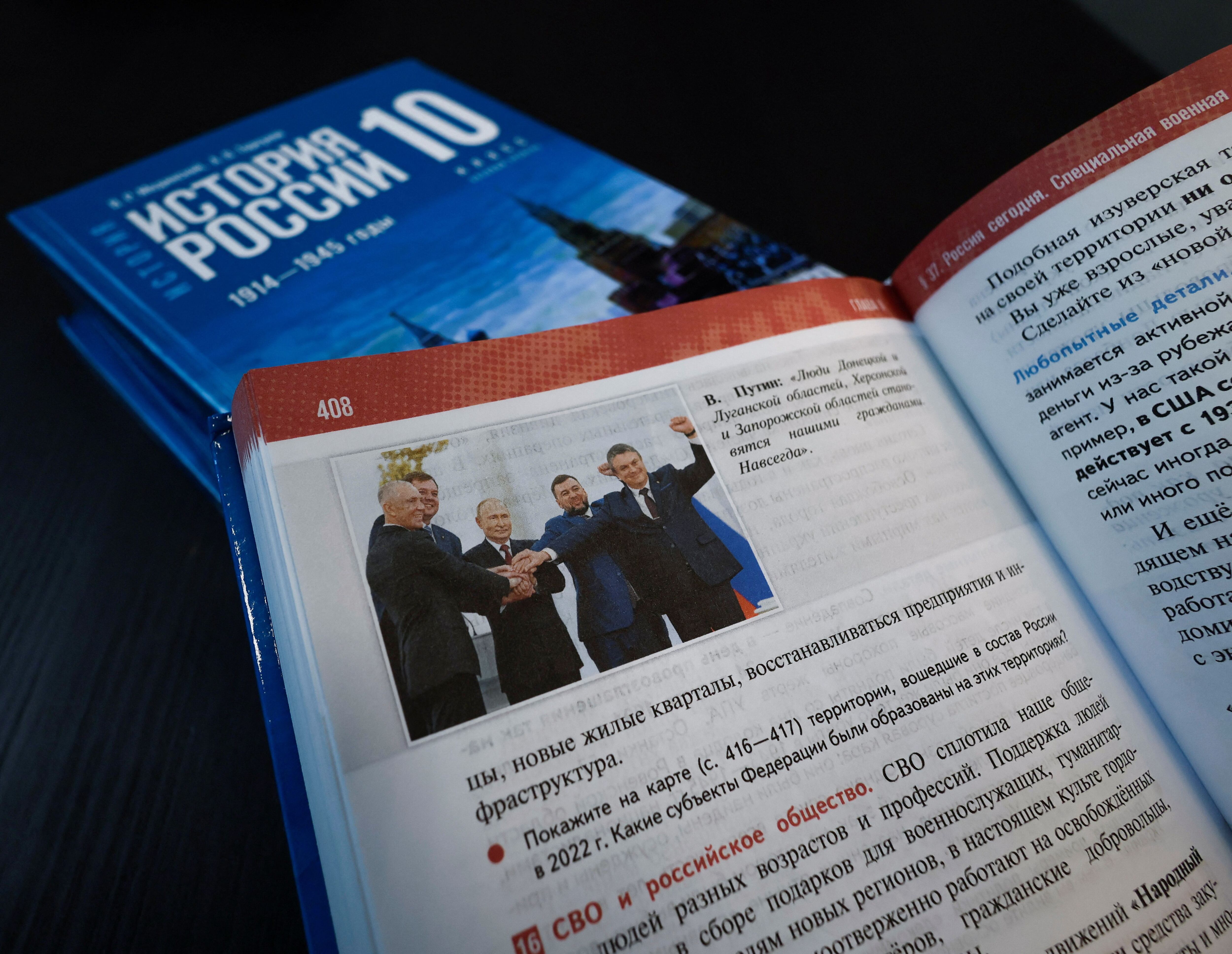 Una fotografía, que muestra al presidente ruso, Vladímir Putin, y a los líderes rusos instalados en las regiones ucranianas de Donetsk, Luhansk, Kherson y Zaporizhzhia, Denis Pushilin, Leonid Pasechnik, Vladímir Saldo y Yevgueni Balitski, durante una ceremonia celebrada en el Gran Palacio del Kremlin de Moscú para declarar la anexión de los territorios de estas regiones controlados por Rusia, se ve en una página del capítulo "Rusia hoy - La operación militar especial" del libro de texto recién publicado para escolares titulado "Historia de Rusia 1945 - el comienzo del siglo XXI" en esta foto de ilustración tomada el 10 de agosto de 2023. REUTERS/Shamil Zhumatov/Ilustración/Archivo