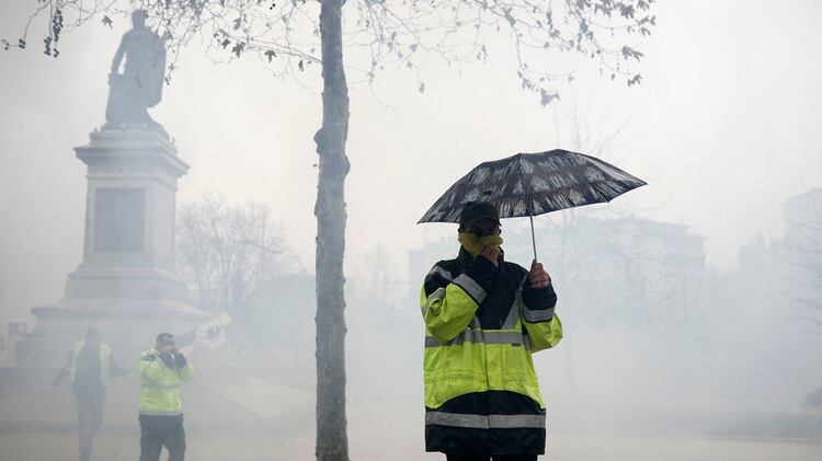 Rostros tapados por el gas lacrimógeno (AP Photo/Kamil Zihnioglu)