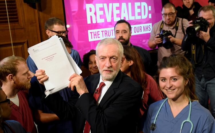 Corbyn sostiene documentos y posa para una foto con el personal del NHS, después de una rueda de prensa durante un evento de campaña en Londres, el 27 de noviembre de 2019 (REUTERS/Toby Melville)
